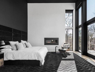 Master bedroom with large windows looking outside.