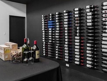 Wine room with multiple wine racks filled with bottles of wine.