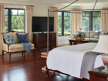 Master bedroom with large canopy bed and wood floors